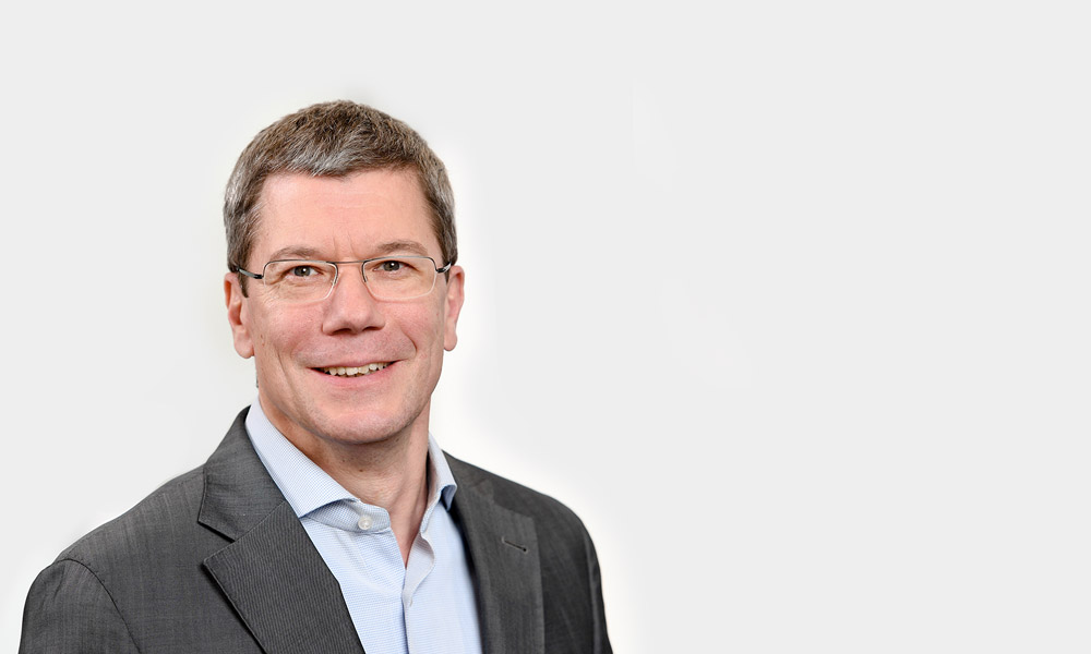 Michael Metzger, Senior Expert Portraetfoto von Michael Metzger vor grauem Hintergrund