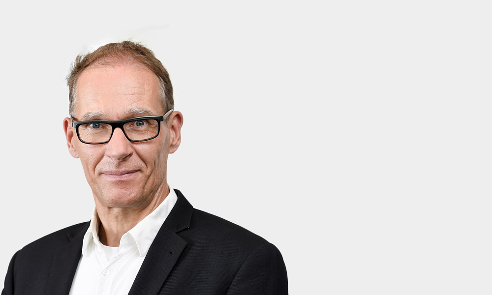 Marc Emde, Senior Expert Portraetfoto von Marc Emde vor grauem Hintergrund