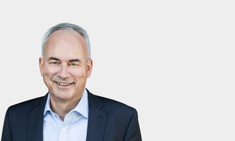 Joachim Krohn, Senior Advisor Portraetfoto von Joachim Krohn vor grauem Hintergrund