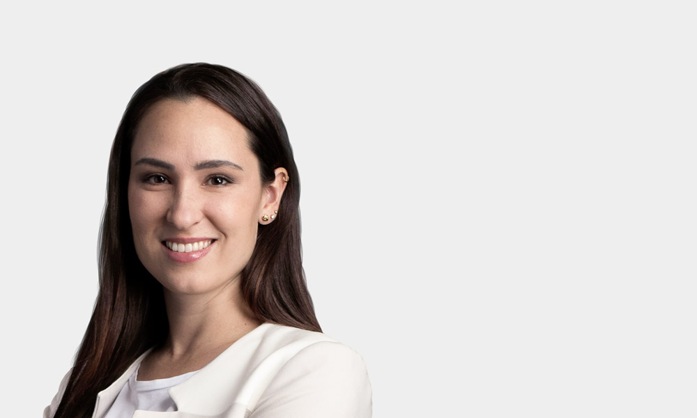 Carolin Stuerzl, Leitung Backoffice Portraetfoto von Carolin Stuerzl vor grauem Hintergrund